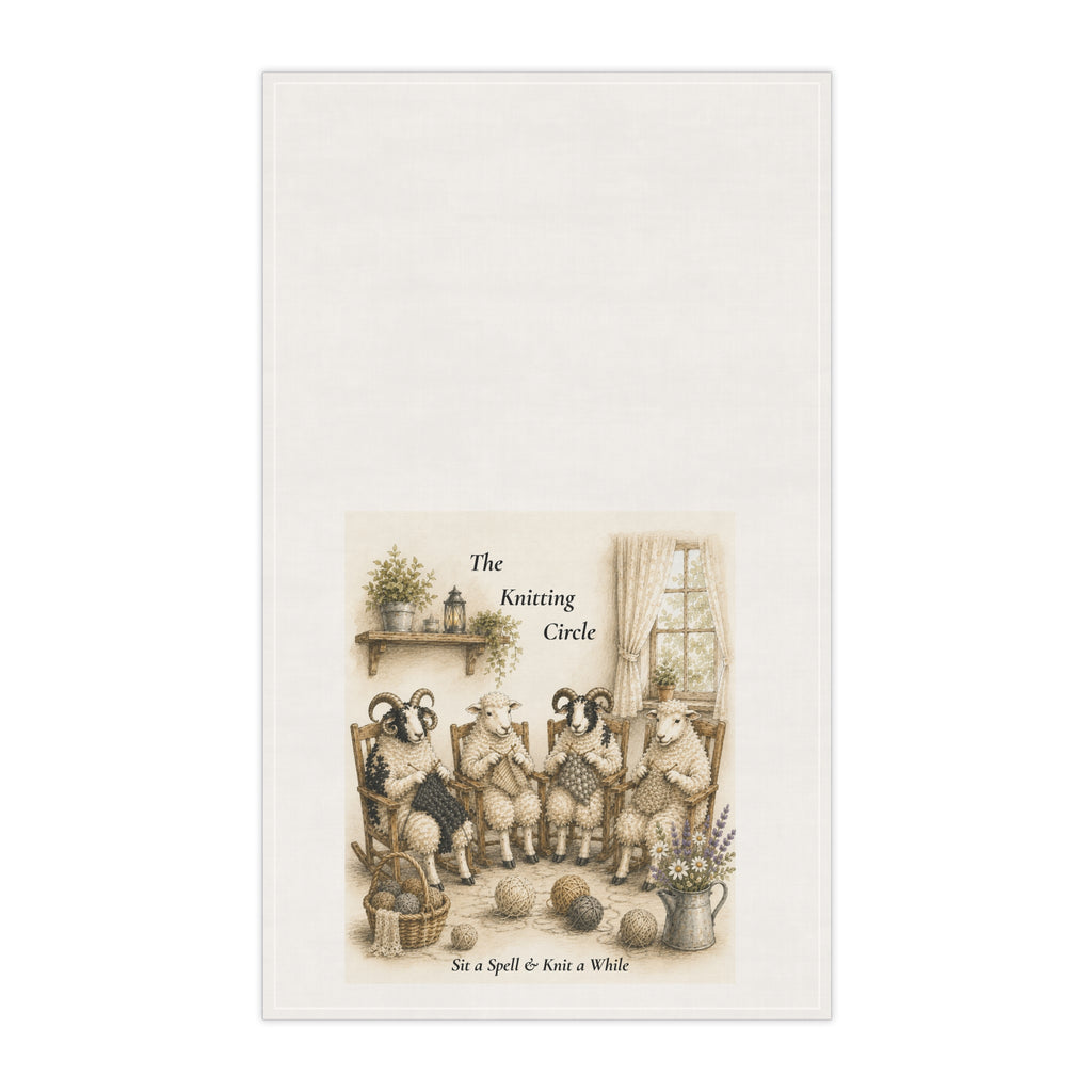 An off-white tea towel featuring a vintage-style illustration of four sheep knitting in a cozy room, with the text 'The Knitting Circle' and 'Sit a Spell & Knit a While' printed on the lower portion.
